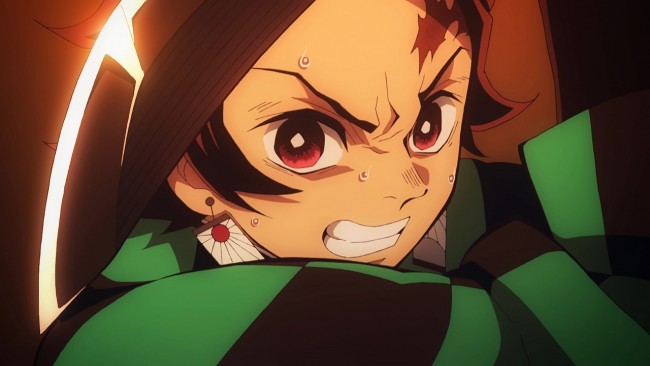 kimetsu no yaiba review, tanjiro kamado grimacing with determination in a close-up during a fight